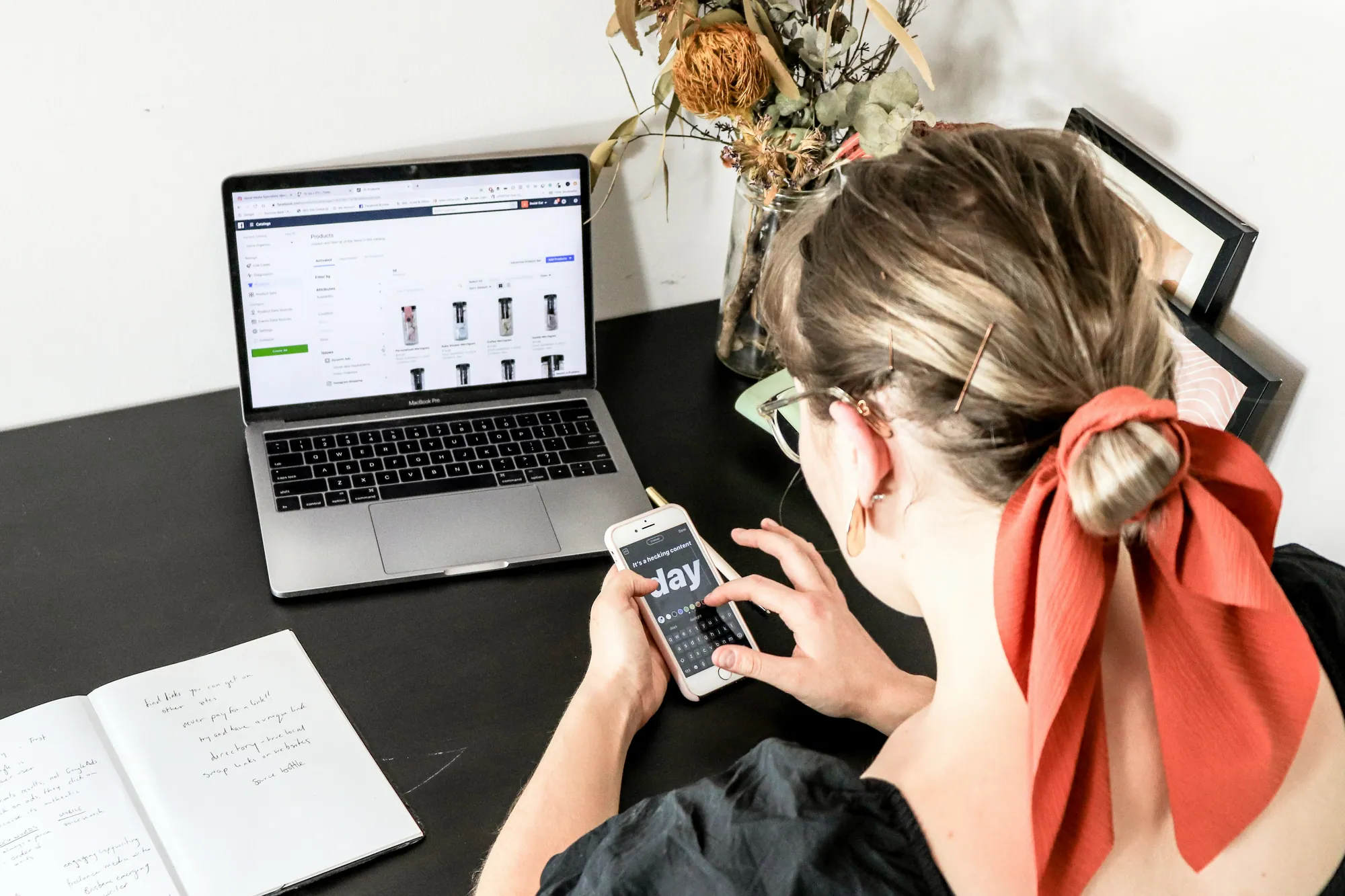 Person browsing on phone with laptop open