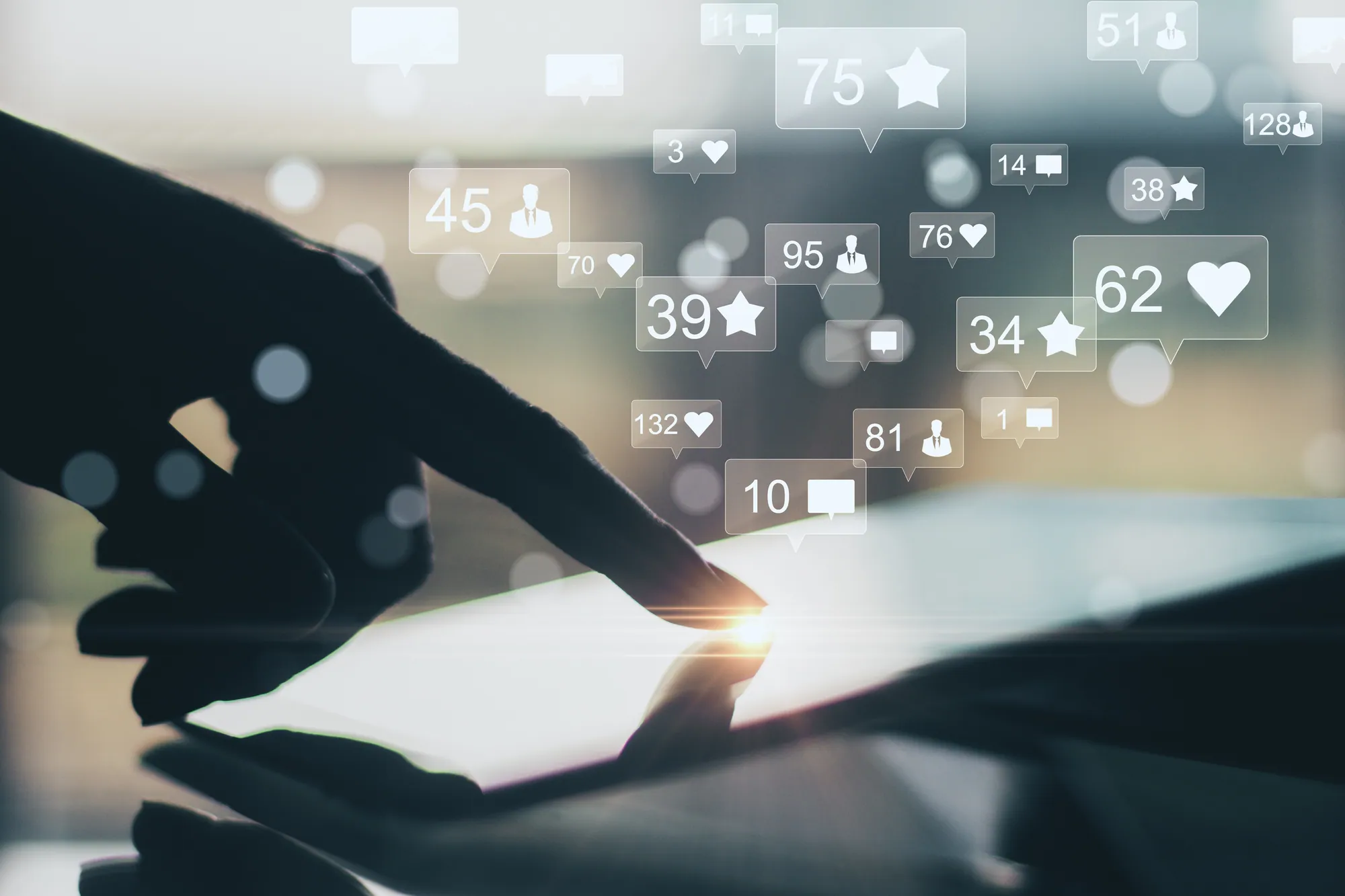 Hand tapping a tablet with social media engagement icons